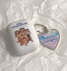 an apple shaped keychain with the name angel on it next to another one