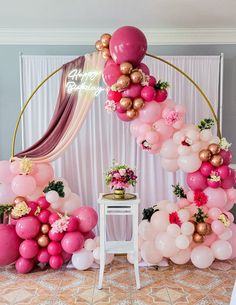 the balloon arch is decorated with pink, gold and white balloons