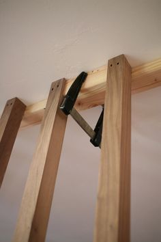 a pair of tools is stuck in between two wooden beams