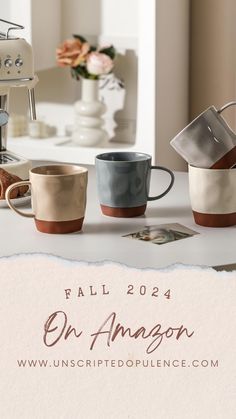 four coffee cups sitting on top of a counter next to an espresso machine