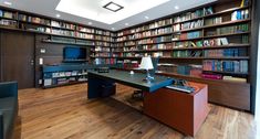 an office with bookshelves and desk in the center