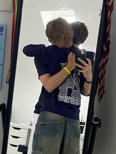 a young man taking a selfie in front of a mirror