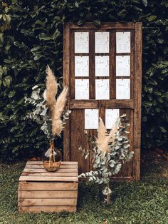 a wooden box with some plants in it next to a sign that says wedding seating