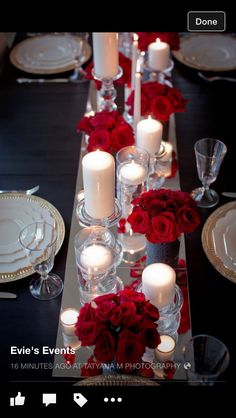 the table is set with candles and red roses in vases for centerpieces