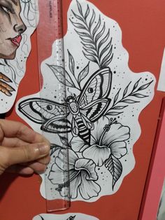 a person holding a pencil in front of some stickers on a red wall with flowers and butterflies