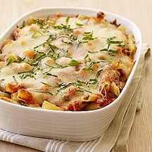 a casserole dish with meat and vegetables in it on a napkin next to a fork