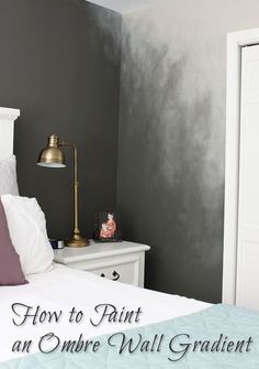 a white bed sitting in a bedroom next to a wall painted black and white with gold accents