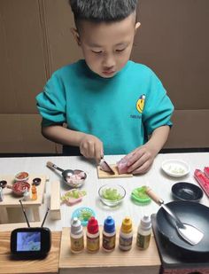 a little boy that is standing in front of a table with some food on it