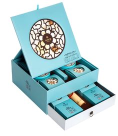 an open blue box with four teas in it and a round window on the top