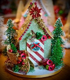 there is a small christmas house with decorations on the front and sides, along with other ornaments