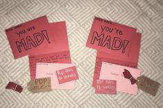 two pieces of pink paper with words on them and tags attached to the side of each piece