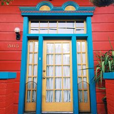 a red building with blue trim and yellow door