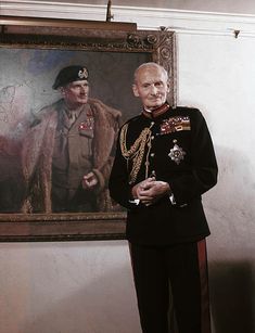 an older man in uniform standing next to a painting