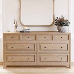 a wooden dresser with a mirror on top of it next to a vase filled with flowers