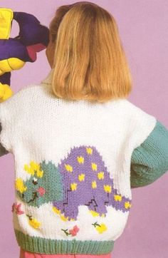 the back of a woman's sweater with an image of a dinosaur on it