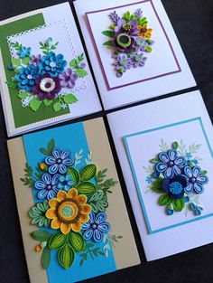 four cards with flowers on them sitting next to each other