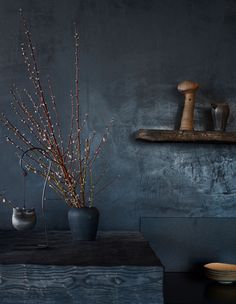 a vase filled with flowers sitting on top of a table next to a wooden shelf