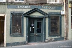 an old building with shutters on the front and side windows that say bacchus antiques