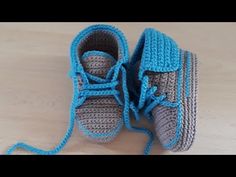 a pair of crocheted shoes with blue laces on the top and bottom