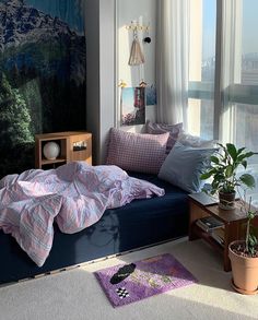 a bedroom with a bed, plant and large window