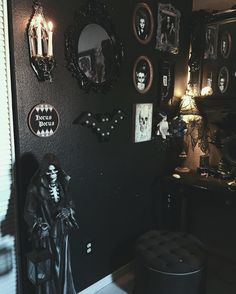 a room decorated for halloween with black walls and pictures on the wall