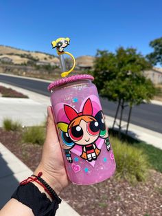 a person holding up a pink cup with a cartoon character on the top and bottom