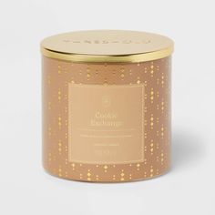 a candle in a gold tin on a white background