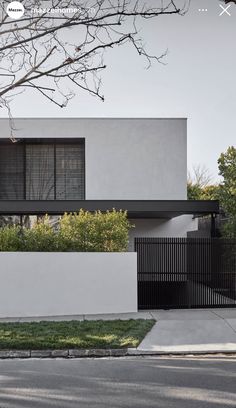 an image of a modern house with black and white architecture on the front yard, as seen from across the street