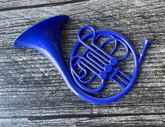 a blue french horn laying on top of a wooden table