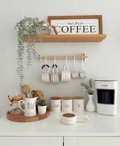 a kitchen counter with coffee cups and mugs hanging on the wall next to a microwave