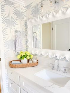 a bathroom with a sink, mirror and flowers in the basket on the counter top