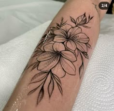 a black and white flower tattoo on the arm