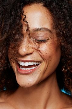 a smiling woman with freckles on her face