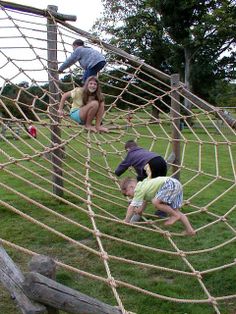 three children climbing up and down a rope net