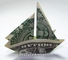 an origami sailboat made out of one dollar bill is seen in this image