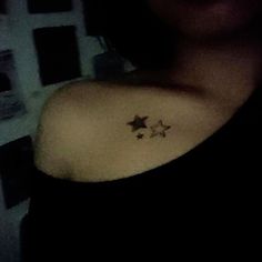 a woman's arm with three stars tattoo on the left side of her shoulder