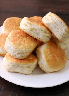 a white plate topped with biscuits on top of a wooden table