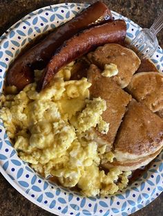 a breakfast plate with eggs, sausage and pancakes on it is ready to be eaten