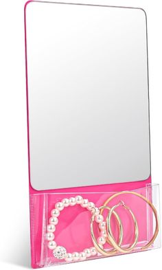 a pink jewelry box with two bracelets and a mirror