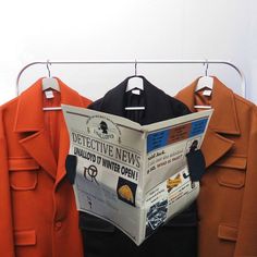 an orange coat hanging on a clothes rack