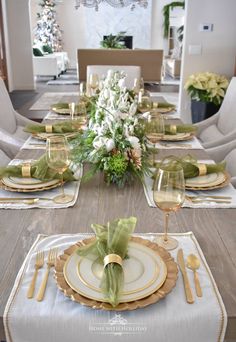 the table is set with gold and white plates, silverware, and green napkins