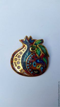 a colorful brooch sitting on top of a white surface