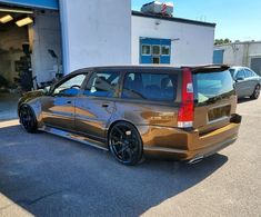 a brown car parked in front of a building