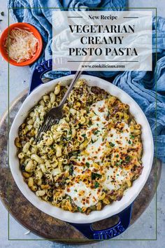 vegetarian creamy pesto pasta in a white dish with a serving spoon on the side