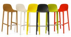 four different colored stools are lined up in the same row and one is black, white, yellow, red