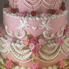 a pink and white cake with flowers on it