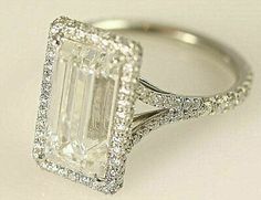 an emerald cut diamond ring with pave set shoulders