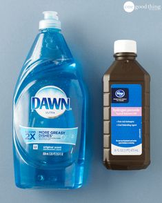 a bottle of dawn water next to a container of dish soap on a blue surface