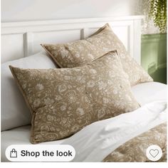 a bed with two pillows on top of it and the words shop the look above them