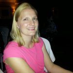 a woman in a pink shirt sitting at a table